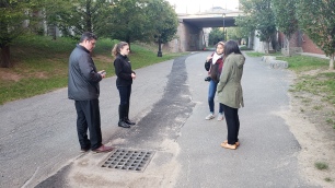 Youth walking with Chief Cook and Lauren Zingarelli of Environment Department observing storm drain